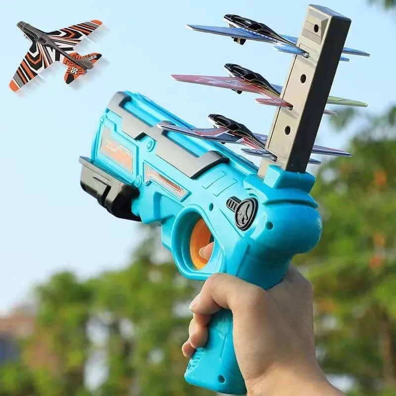 Airplane launcher toy in hand, shooting colorful foam glider planes into the sky for outdoor fun.